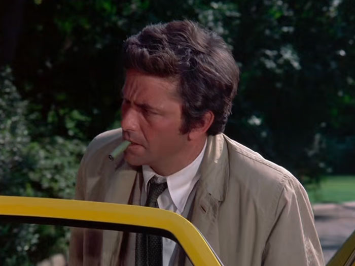『刑事コロンボ』で、車の外で緑の葉巻を咥えるコロンボ