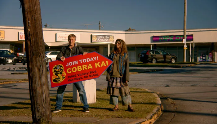 『コブラ会』で、ホームレスの女性にサインスピナーをさせるジョニー