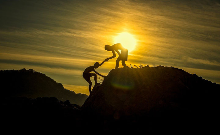朝日が登る中、山に登る子供二人