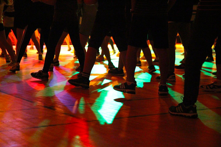 足下が照らされる中ダンスする人々